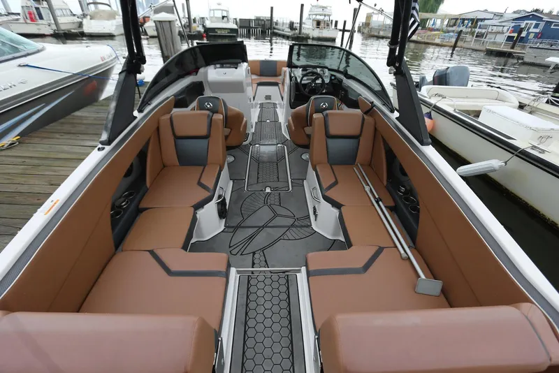 Slide: The Image of 2017 Scarab 255 Impulse boat interior with brown seating and modern design at a marina. - 21