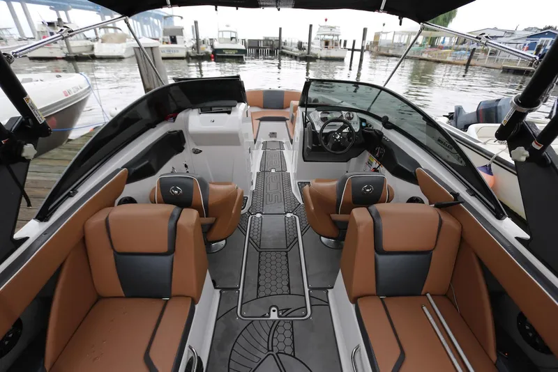 Slide: The Image of 2017 Scarab 255 Impulse boat interior with tan and black seating, docked at marina. - 23