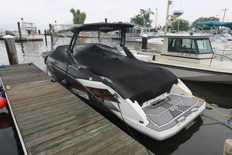 Slide: The Image of 2017 Scarab 255 Impulse boat docked, covered with a black tarp, in a marina setting. - 3