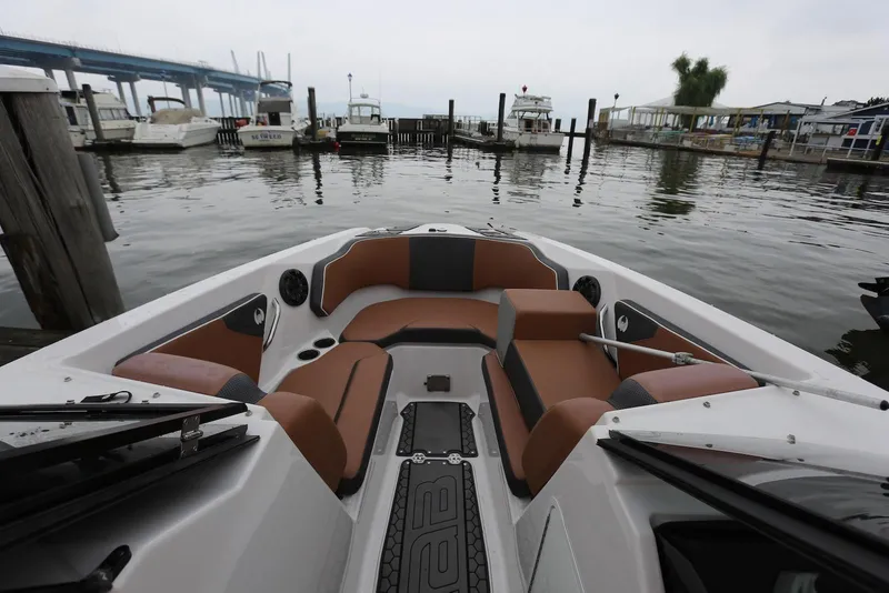 Slide: The Image of 2017 Scarab 255 Impulse boat interior at marina, featuring brown seating and waterfront view. - 36