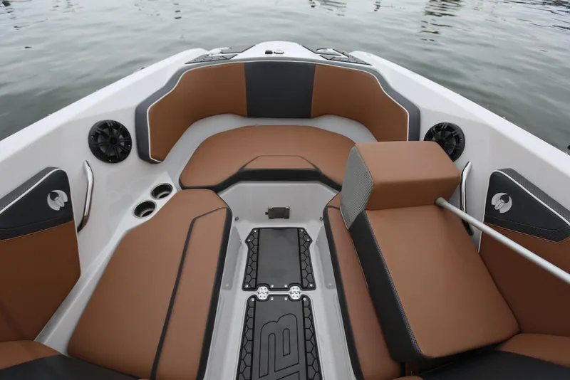 Slide: The Image of 2017 Scarab 255 Impulse boat interior with brown seating and cup holders on calm water. - 37