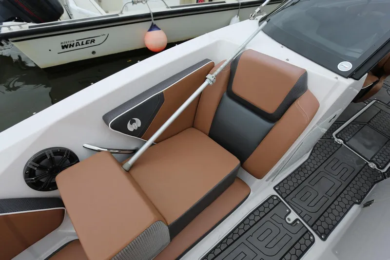 Slide: The Image of 2017 Scarab 255 Impulse boat interior with brown and black seating, speaker, and branded flooring. - 40