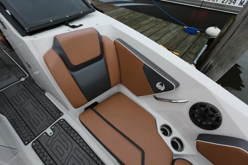 Slide: The Image of 2017 Scarab 255 Impulse boat interior with tan and black seating, speaker, and dock view. - 43