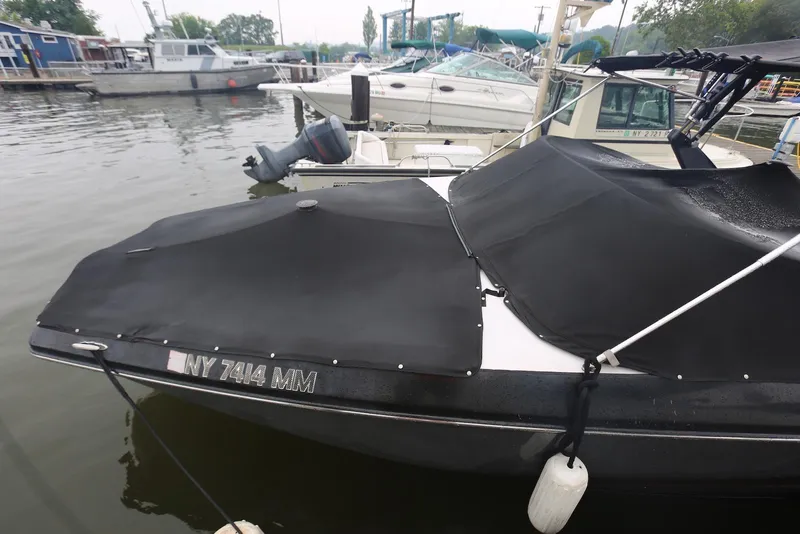 Slide: The Image of 2017 Scarab 255 Impulse boat docked with black cover, marina background. - 6