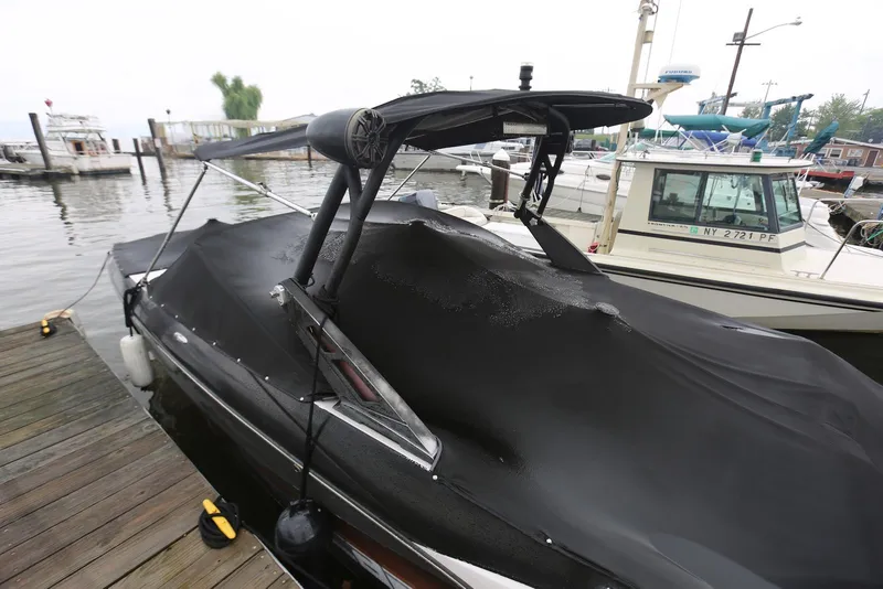 Slide: The Image of 2017 Scarab 255 Impulse boat docked with black cover, marina background. - 8