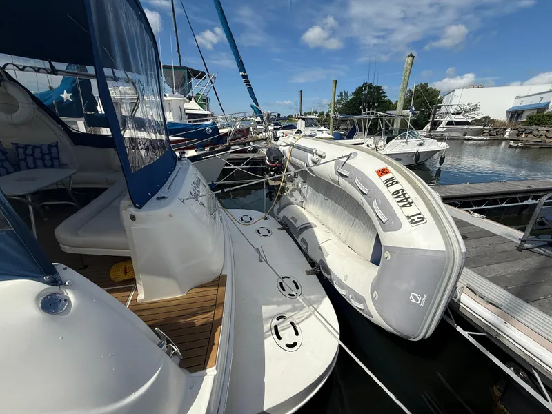 Slide: The Image of 2003 Sea Ray 380 Sundancer docked with inflatable boat, under clear blue sky. - 11
