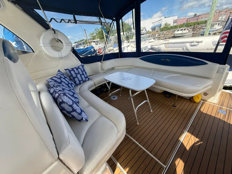 Slide: The Image of 2003 Sea Ray 380 Sundancer interior with white seating, blue cushions, and wooden flooring. - 14