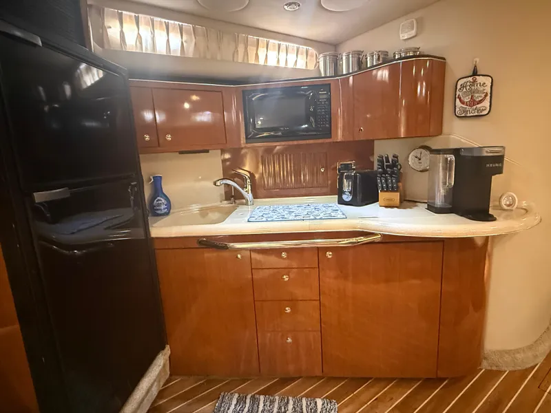 Slide: The Image of 2003 Sea Ray 380 Sundancer kitchen with wood cabinets, appliances, and countertop. - 21