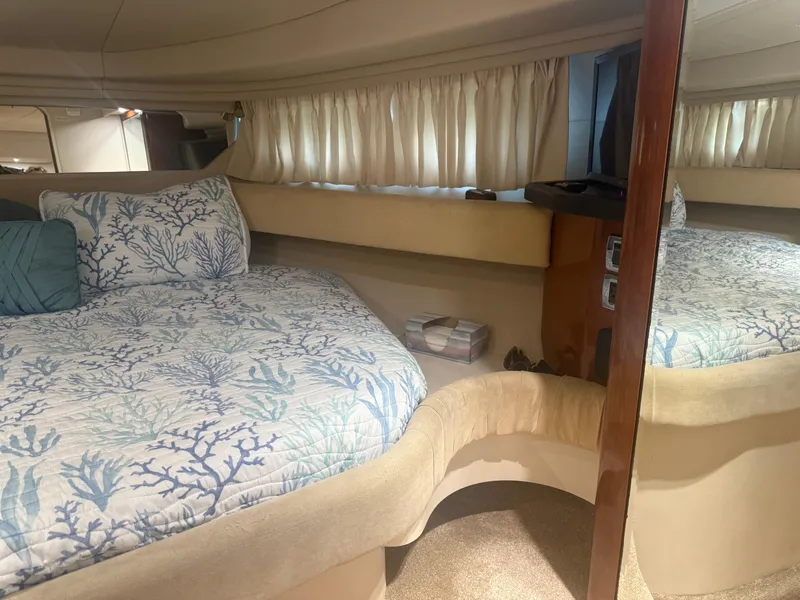 Slide: The Image of Interior of 2003 Sea Ray 380 Sundancer with cozy bed and nautical-themed bedding. - 26