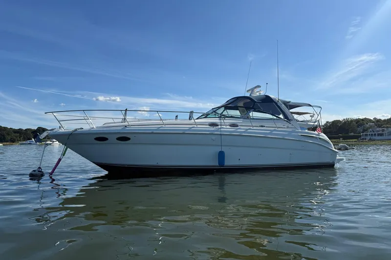 Slide: The Image of 2003 Sea Ray 380 Sundancer yacht on calm water under clear blue sky. - 3