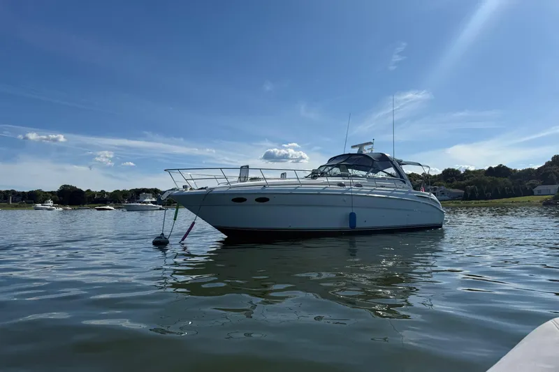 Slide: The Image of 2003 Sea Ray 380 Sundancer yacht anchored on calm water under a clear blue sky. - 4