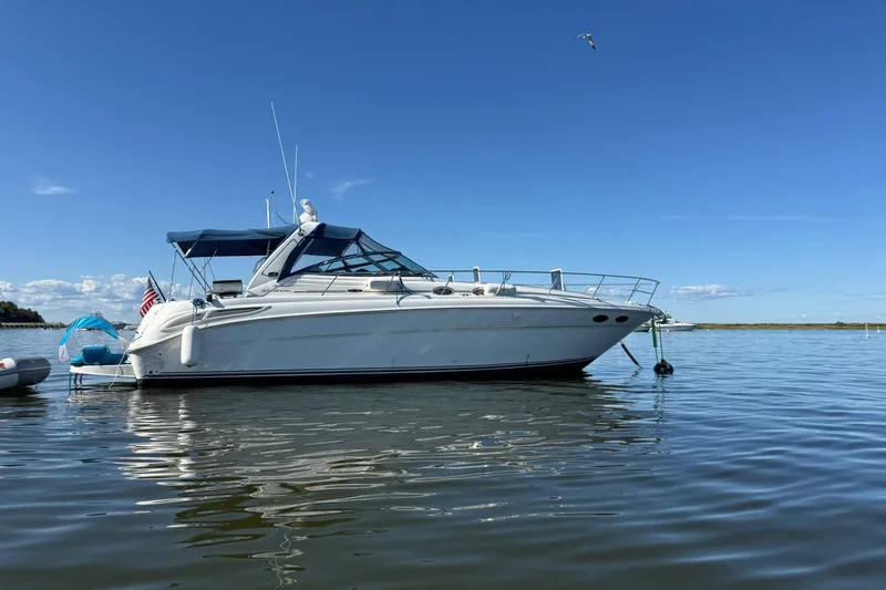 Slide: The Image of 2003 Sea Ray 380 Sundancer yacht anchored on calm water under clear blue sky. - 5