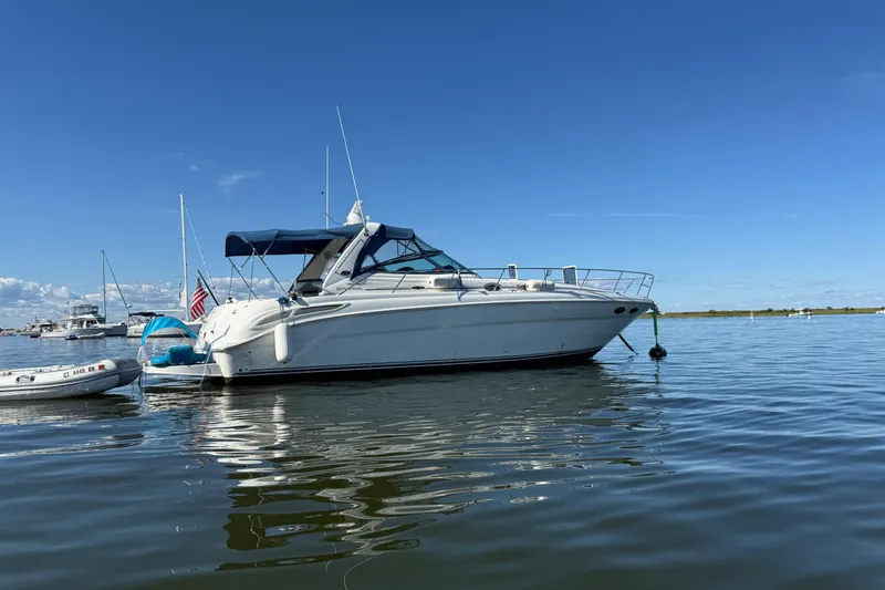 Slide: The Image of 2003 Sea Ray 380 Sundancer yacht anchored on calm water under clear blue sky. - 6