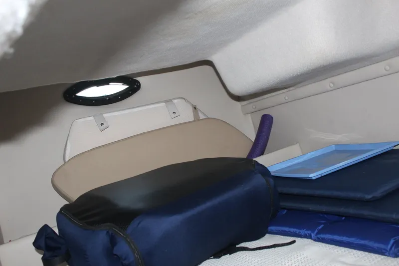 Slide: The Image of Interior cabin of 2000 Regal Commodore 2760 boat with cushions and storage items. - 26
