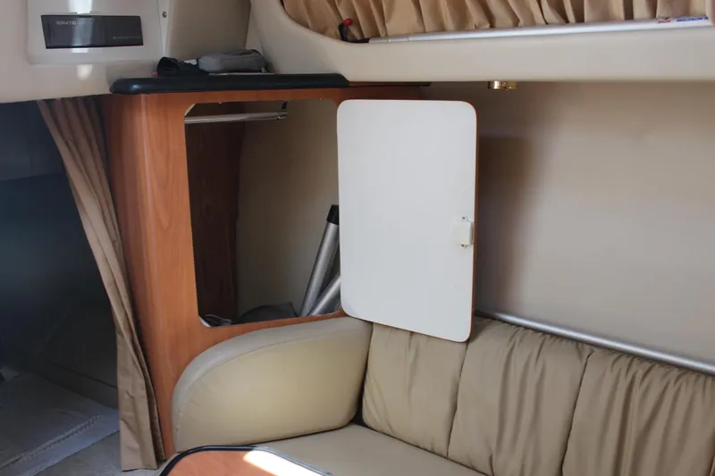 Slide: The Image of Interior of 2000 Regal Commodore 2760 boat with open storage compartment and beige seating. - 27