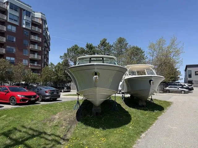Slide: The Image of 2025 Grady-White Freedom 325 boats on display in a parking area, sunny day. - 3