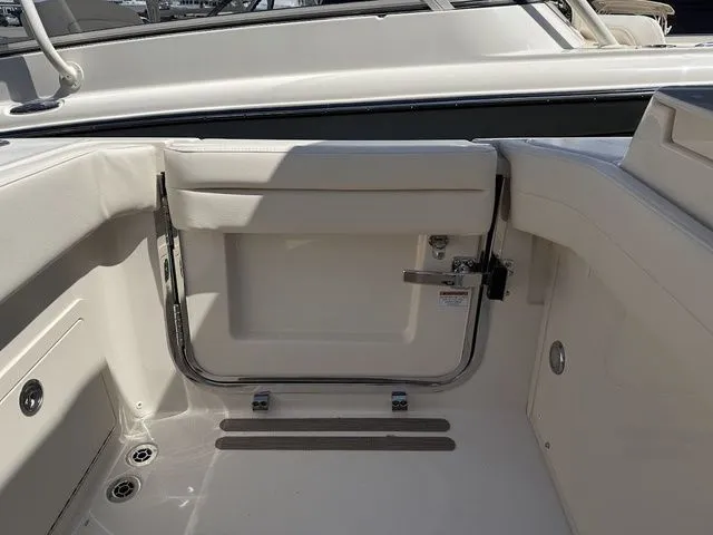 Slide: The Image of 2025 Grady-White Freedom 325 boat interior, featuring sleek white seating and stainless steel fixtures. - 9