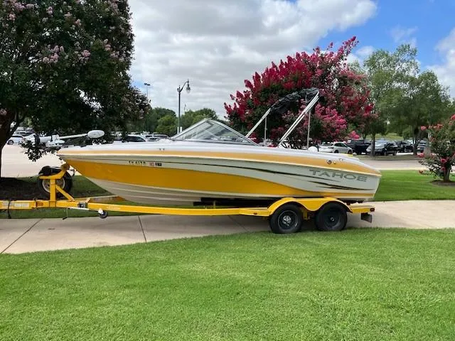 Slide: The Image of 2008 Tahoe Q6SF I/O boat on trailer, parked on grass with trees in background. - 5