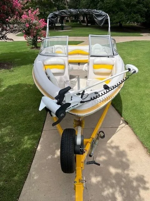 Slide: The Image of 2008 Tahoe Q6SF I/O boat on trailer, yellow accents, parked on driveway. - 7