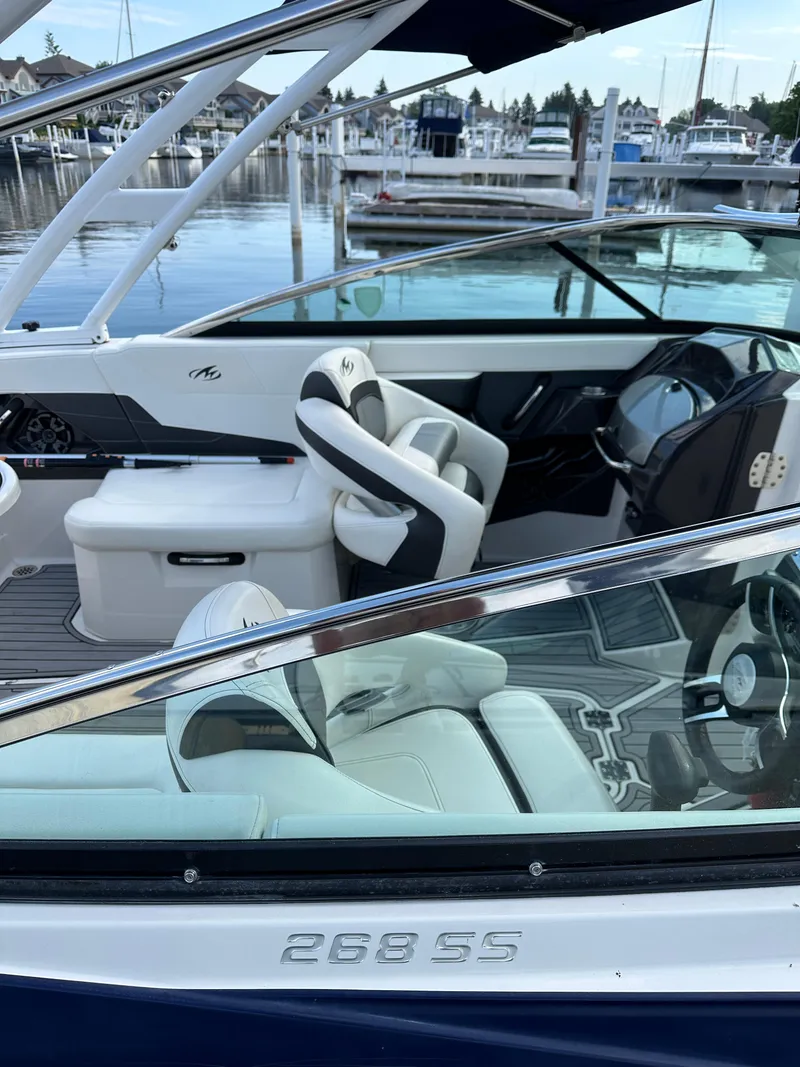 Slide: The Image of 2014 Monterey 268 Super Sport boat interior at marina, featuring sleek seating and dashboard. - 29