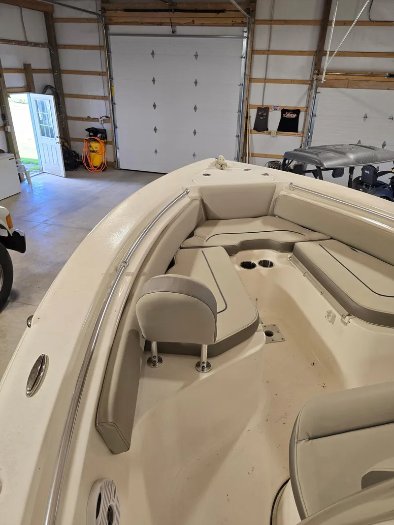 Slide: The Image of 2023 Key West 219 FS boat interior with cushioned seating in a garage setting. - 2