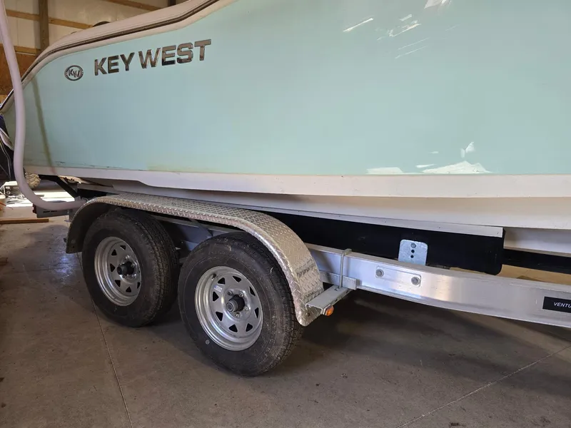 Slide: The Image of 2023 Key West 219 FS boat on trailer in garage setting. - 22
