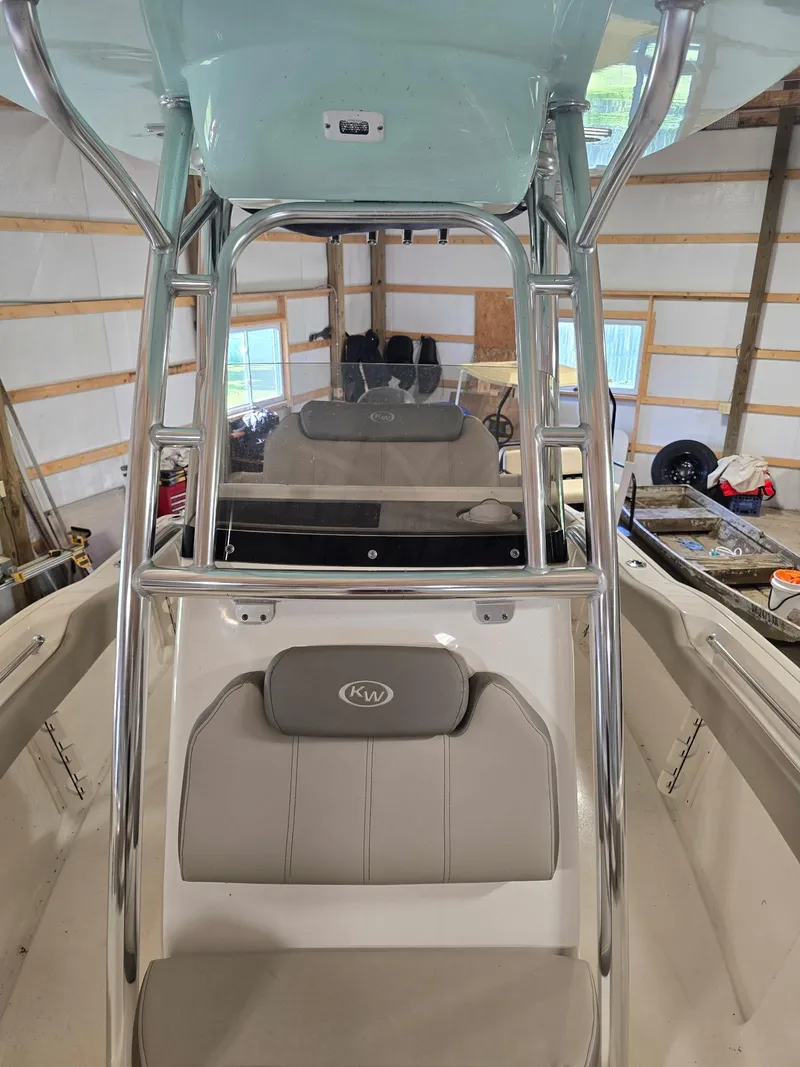 Slide: The Image of 2023 Key West 219 FS boat interior with seating and console in a garage. - 4