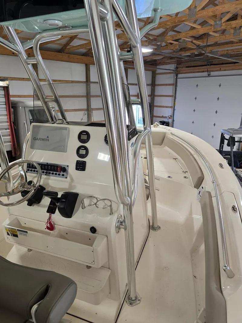 Slide: The Image of 2023 Key West 219 FS boat interior with Garmin navigation, steering wheel, and stainless steel frame. - 5