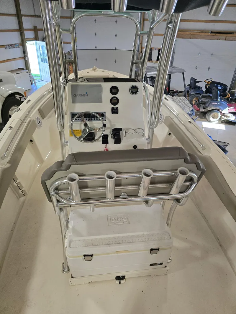 Slide: The Image of 2023 Key West 219 FS boat interior with console and rod holders in a garage. - 9