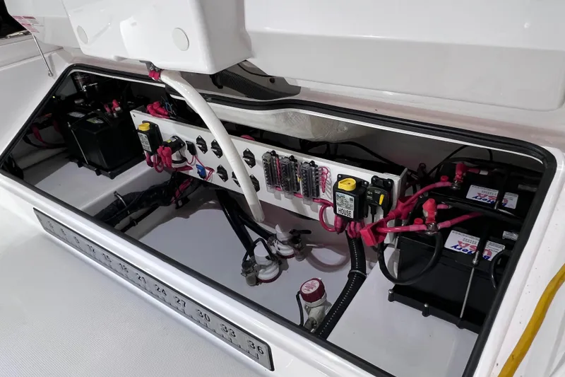 Slide: The Image of Electrical compartment of 2021 Everglades 253 Center Console boat, showcasing wiring and batteries. - 23