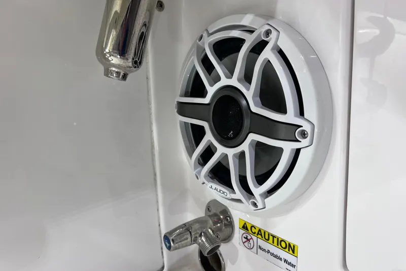 Slide: The Image of Speaker and faucet on 2021 Everglades 253 Center Console boat, caution sign visible. - 28