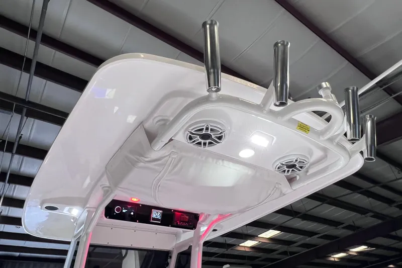 Slide: The Image of 2021 Everglades 253 Center Console boat with rod holders and speakers in a warehouse. - 35