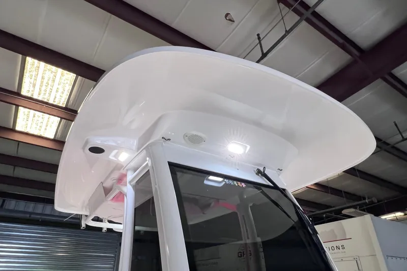 Slide: The Image of 2021 Everglades 253 Center Console boat with illuminated T-top in a warehouse setting. - 36