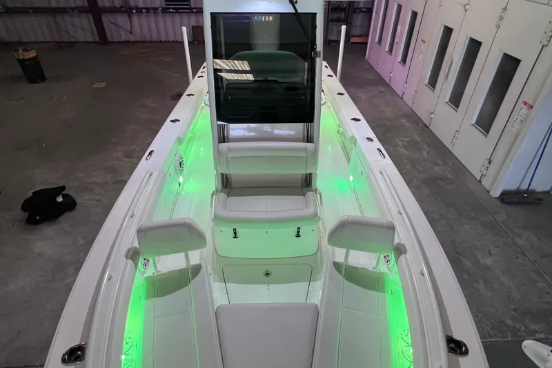 Slide: The Image of 2021 Everglades 253 Center Console boat with green LED lighting in a warehouse. - 57