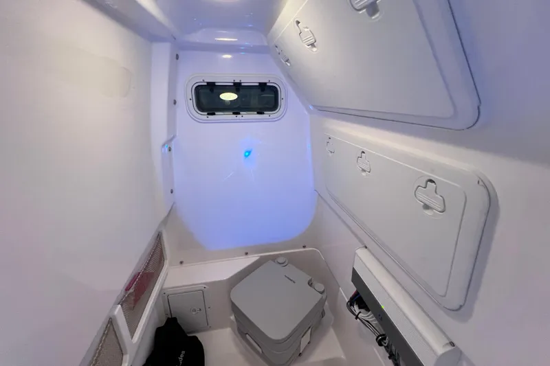 Slide: The Image of Interior of 2021 Everglades 253 Center Console boat with compact toilet and storage. - 67