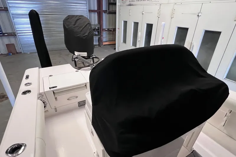 Slide: The Image of 2021 Everglades 253 Center Console boat interior with covered seats in a garage. - 7