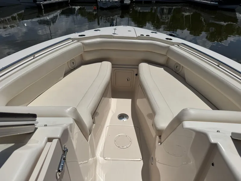 Slide: The Image of 2018 Grady-White Freedom 307 boat interior with cushioned seating and storage compartments. - 16