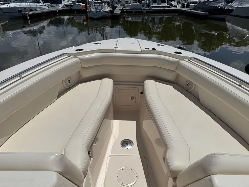 Slide: The Image of 2018 Grady-White Freedom 307 boat interior with beige seating at marina. - 17