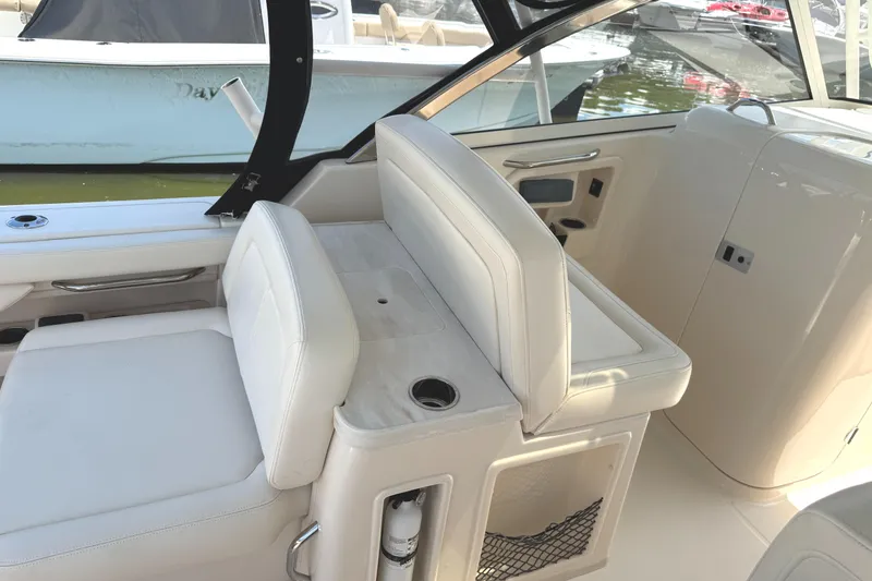 Slide: The Image of 2018 Grady-White Freedom 307 boat interior with white seating and storage compartments. - 26
