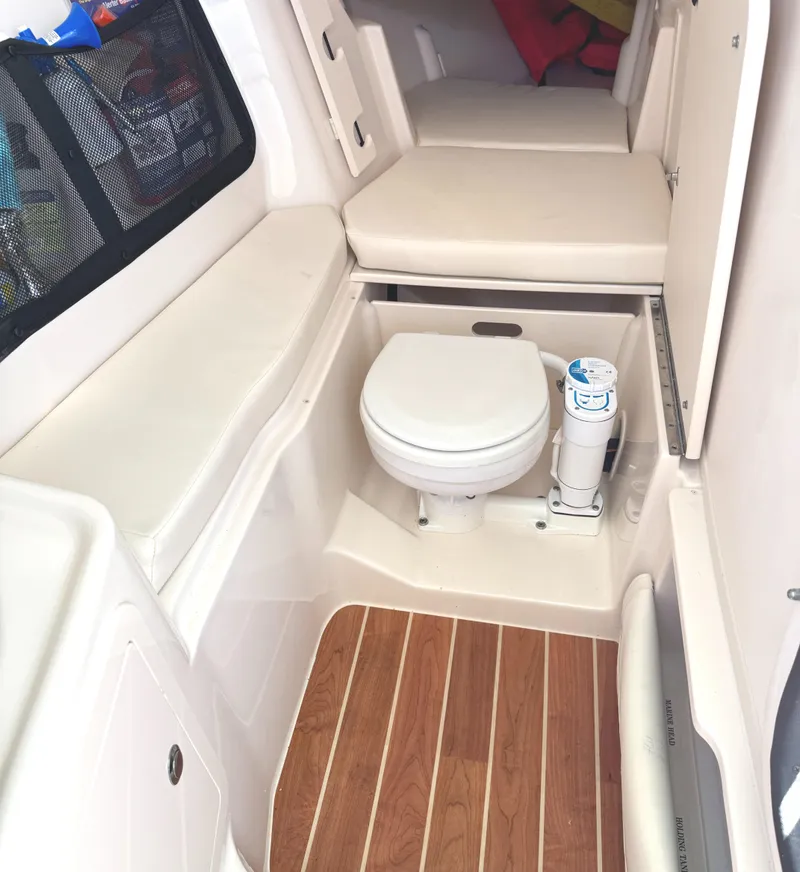 Slide: The Image of 2018 Grady-White Freedom 307 boat interior with toilet and cushioned seating. - 30