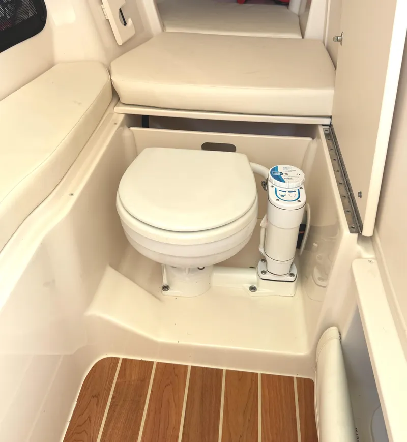 Slide: The Image of 2018 Grady-White Freedom 307 boat interior with toilet and wooden flooring. - 33
