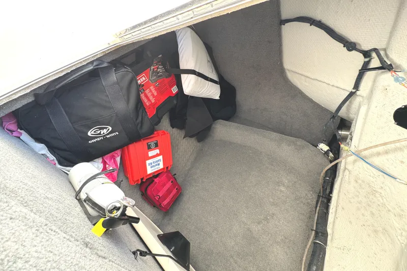 Slide: The Image of Storage compartment of 2018 Grady-White Freedom 307 boat with bags and equipment. - 34