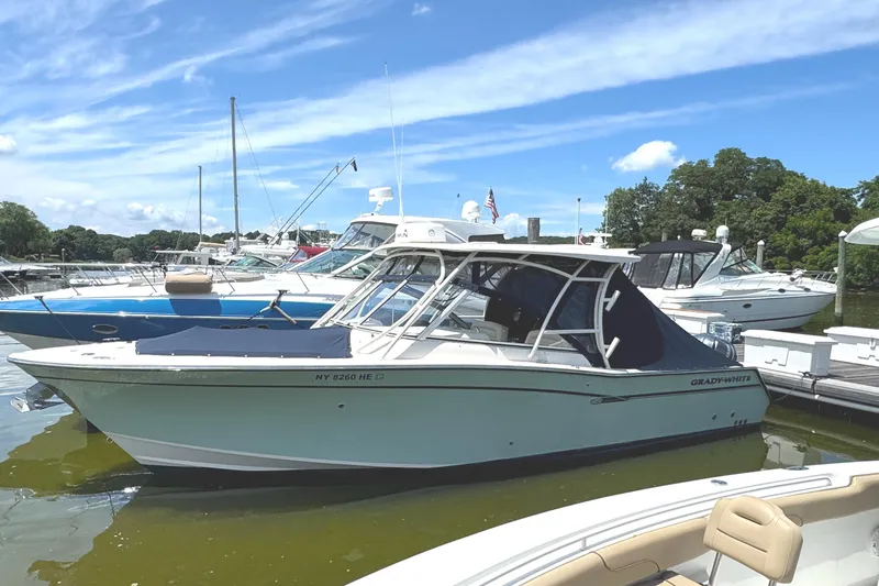 Slide: The Image of 2018 Grady-White Freedom 307 boat docked at marina under blue sky. - 4