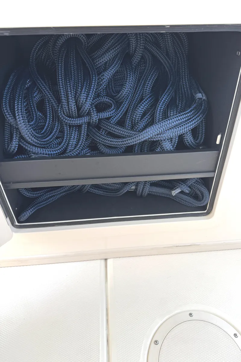 Slide: The Image of Storage compartment with coiled ropes on a 2018 Grady-White Freedom 307 boat. - 42