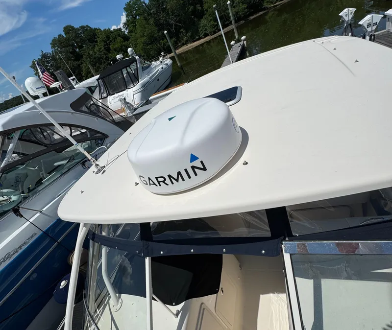 Slide: The Image of 2018 Grady-White Freedom 307 boat with Garmin radar, docked near other vessels. - 44