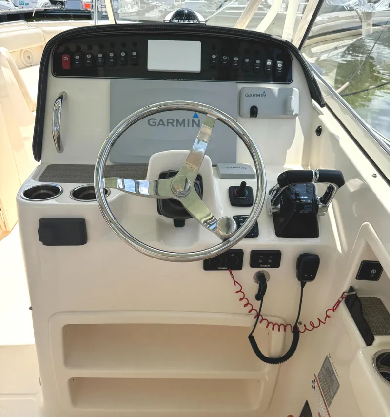 Slide: The Image of 2018 Grady-White Freedom 307 boat helm with Garmin navigation system and steering wheel. - 6
