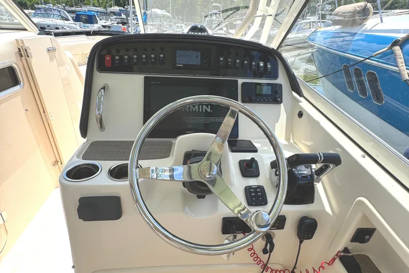 Slide: The Image of 2018 Grady-White Freedom 307 boat helm with steering wheel and control panel. - 8