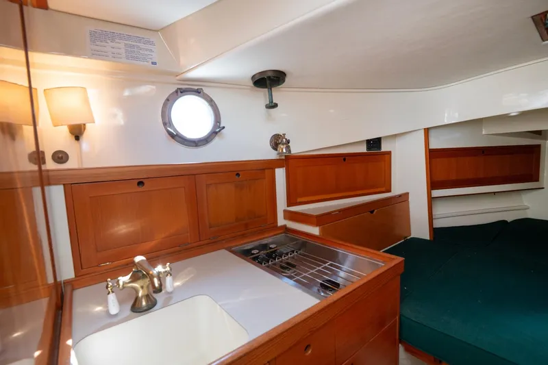 Slide: The Image of Interior of 1997 Belkov Picnic Express boat with wooden cabinetry and compact kitchen. - 2