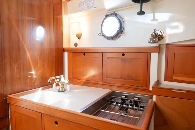 Slide: The Image of Cozy wooden kitchen interior on 1997 Belkov Picnic Express boat, featuring sink and stove. - 6
