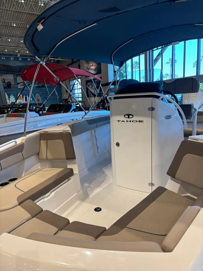 Slide: The Image of 2025 Tahoe 2150 CC boat interior with seating and canopy in showroom. - 3